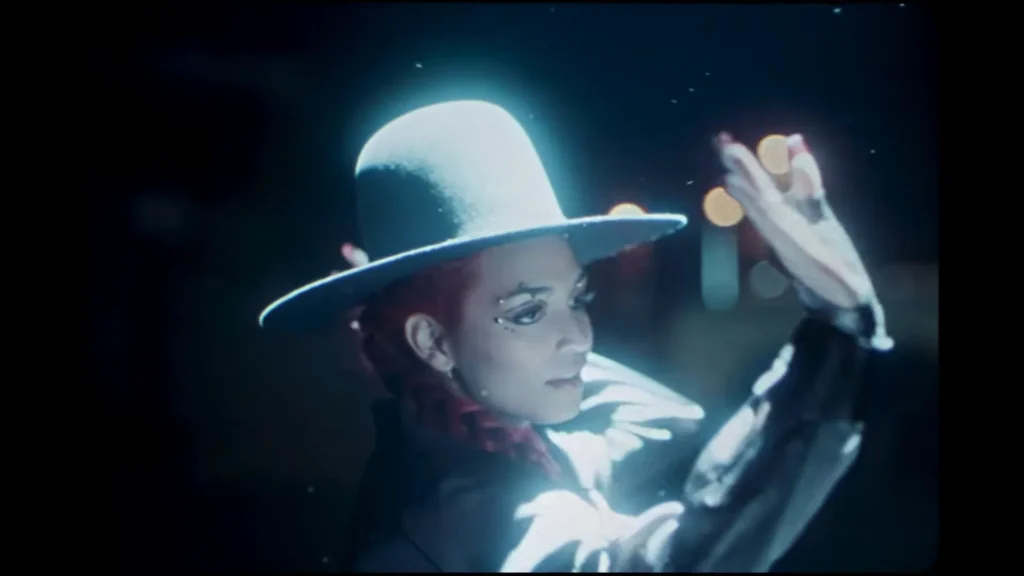 Ambar Lucid surrounded by glowing retro imagery in the Get Lost In The Music music video