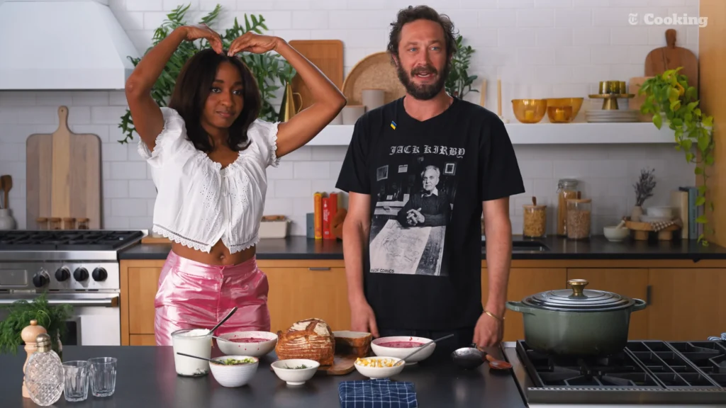 Ayo Edebiri and Ebon Moss-Bachrach presenting finished bowls of borscht