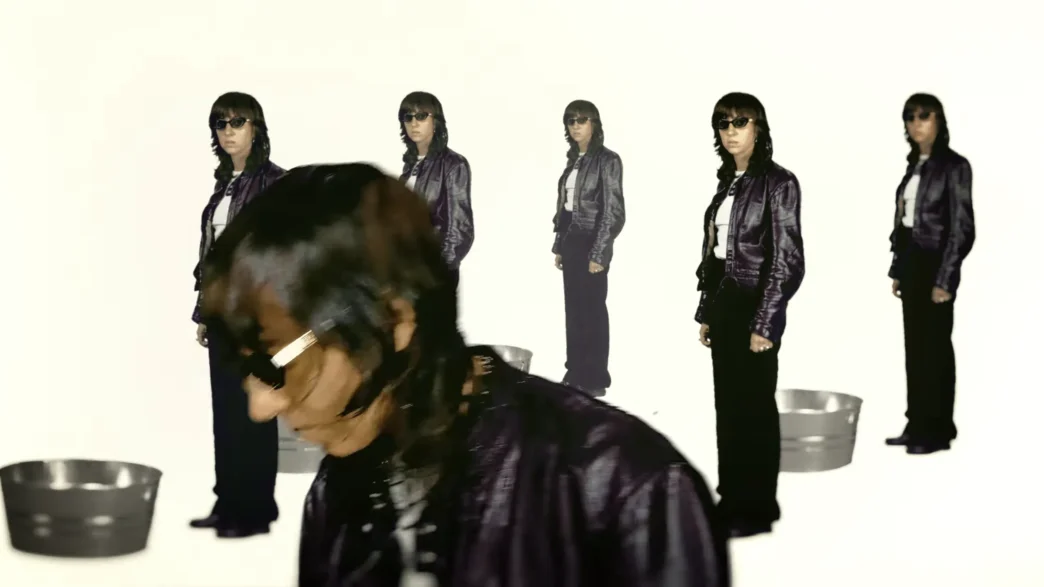 Chloé Caillet appearing in layered duplicate images against a green background in the “Bad Bara” music video