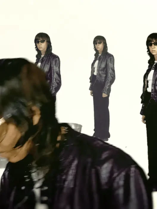 Chloé Caillet appearing in layered duplicate images against a green background in the “Bad Bara” music video