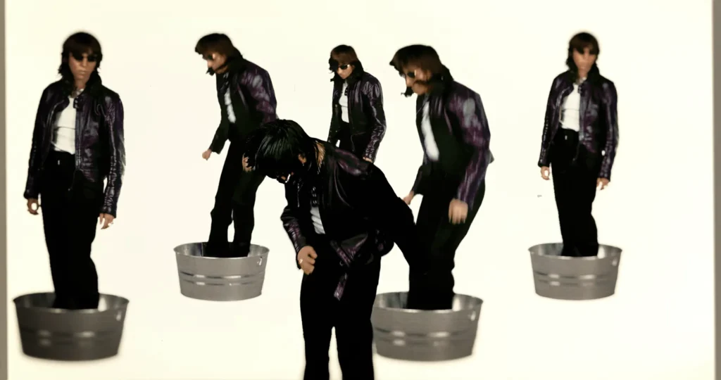 Multiple versions of Chloé Caillet dancing in metal tubs against a white background in the Bad Bara video