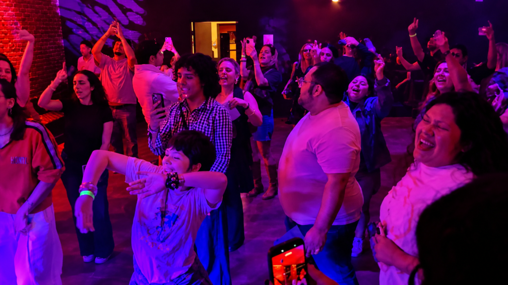 Fans dancing and singing under pink and purple lighting during La Roux’s DJ pop-up at Catch One in Los Angeles.