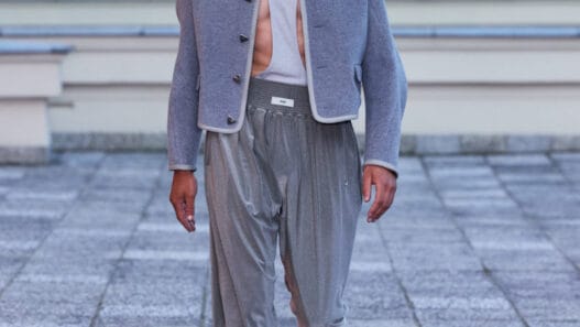 A model walks the GmbH Winter/Spring 2027 runway at Berlin Fashion Week in a structured dark look.