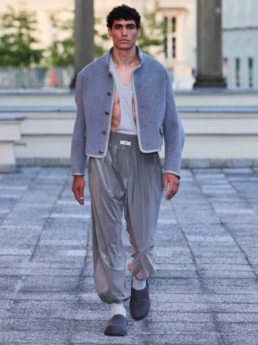 A model walks the GmbH Winter/Spring 2027 runway at Berlin Fashion Week in a structured dark look.