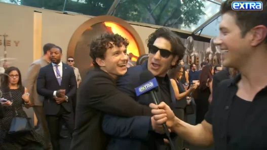 Tom Holland smiling as he crashes Jon Bernthal's interview at The Odyssey New York premiere
