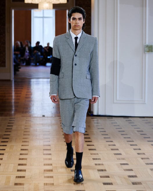 A model walks the Martin Quad Spring/Summer 2027 runway at Berlin Fashion Week in a layered look from Woodman Pt. 2.