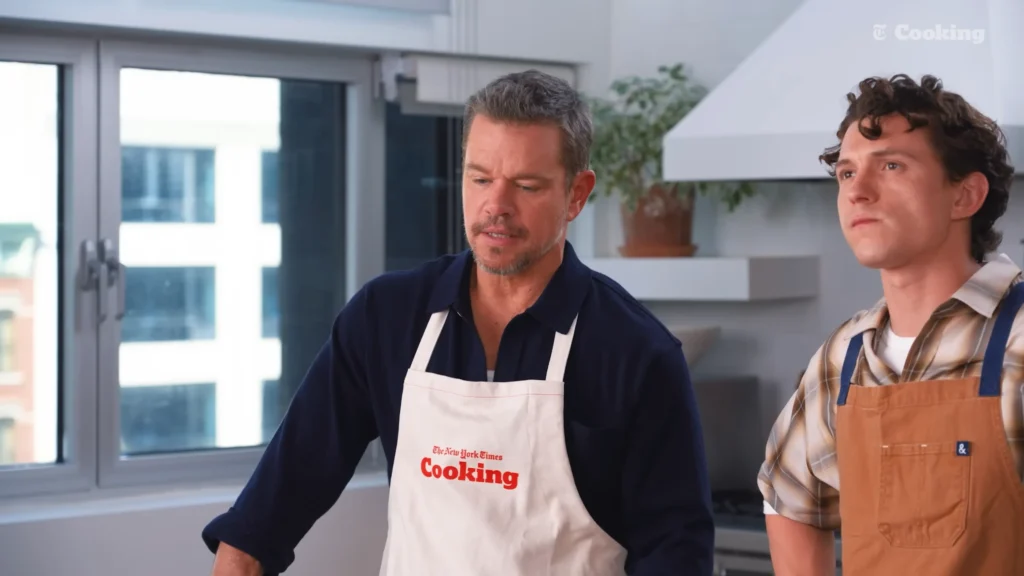 Matt Damon speaking with Tom Holland while their pizzas are prepared