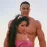 Mýa smiling in a bright yellow retro outfit in the “Give It to You” music video