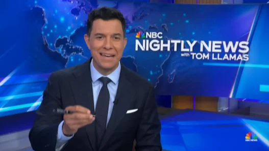 Tom Llamas smiling at the NBC Nightly News desk during the July 13 broadcast