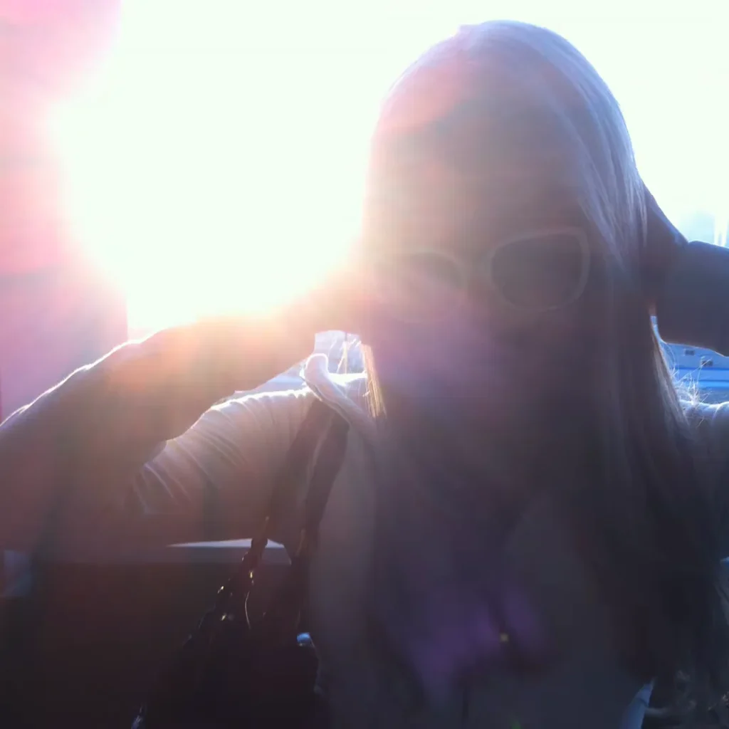 Kim Petras wearing white sunglasses in the sunlit Need For Speed loki Remix visual