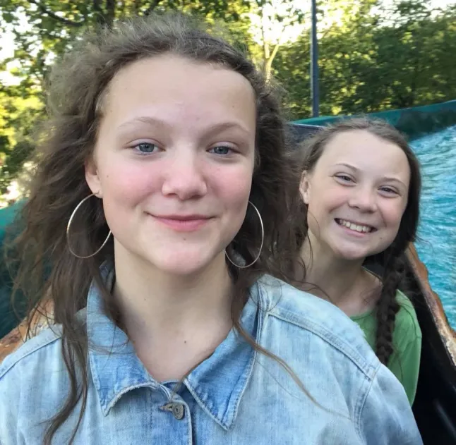Young Greta Thunberg and her younger sister Beata smiling together during a family outing