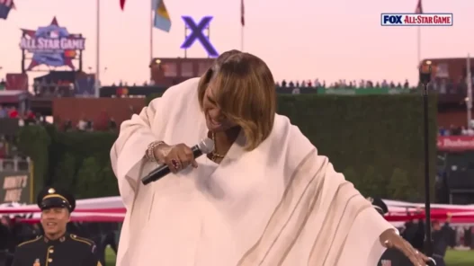 Patti LaBelle raises her hand during the final notes of the national anthem at the MLB All-Star Game
