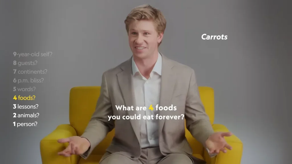 Robert Irwin speaking animatedly while seated in National Geographic’s yellow chair