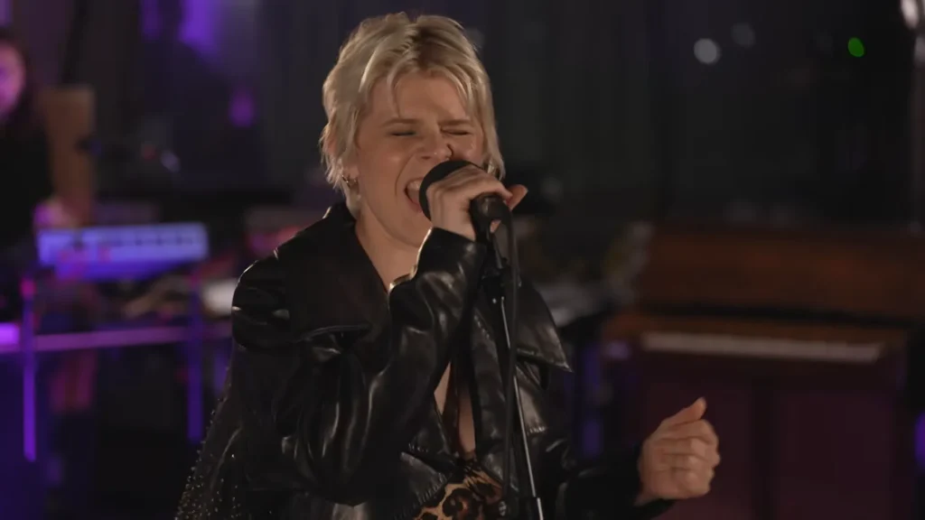 Robyn gestures while performing Sucker for Love in a 6 Music live session