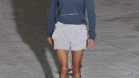 A model walks the SF1OG Spring/Summer 2027 runway at Berlin Fashion Week in a dark, ritual-inspired look.