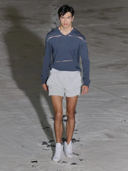 A model walks the SF1OG Spring/Summer 2027 runway at Berlin Fashion Week in a dark, ritual-inspired look.