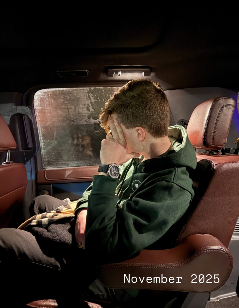 Iain Armitage sitting in a vehicle with one hand over his face in November 2025