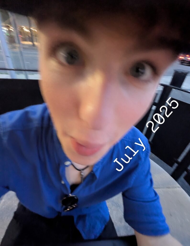 Close-up wide-angle selfie of Iain Armitage wearing a blue shirt in July 2025