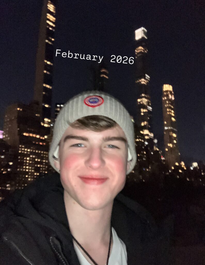 Iain Armitage wearing a knit cap during a nighttime city selfie in February 2026