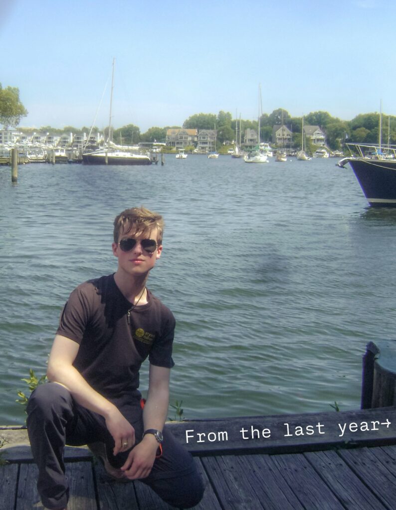Iain Armitage wearing sunglasses beside a marina in a photo from the previous year