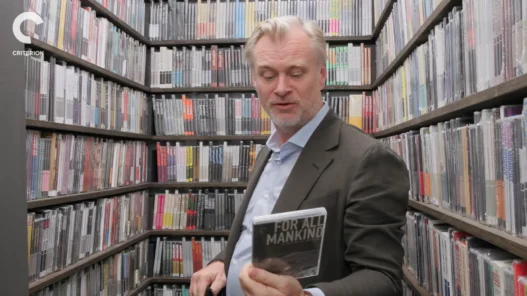 Christopher Nolan holding a Criterion Collection film inside the Closet Picks room