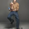 Thatcher Thornton modeling a camel crew neck and denim from FRAME’s Fall 2026 collection