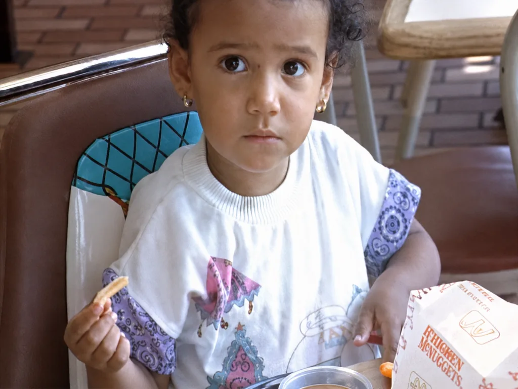 A child sits at a table inside a McDonald’s restaurant in 1990