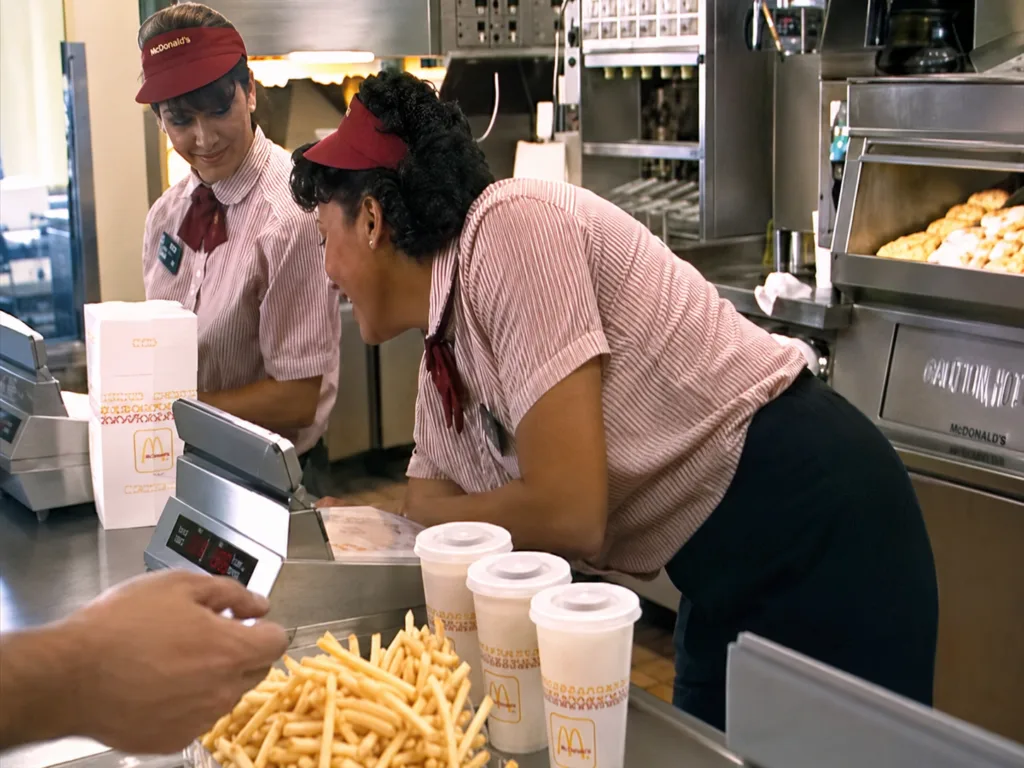 Customers wait at a McDonald’s service counter with multiple registers in 1990