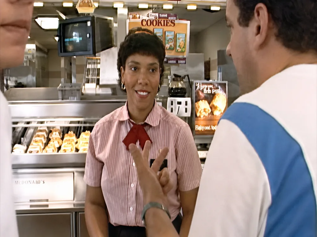 Uniformed McDonald’s employees work behind the registers in 1990