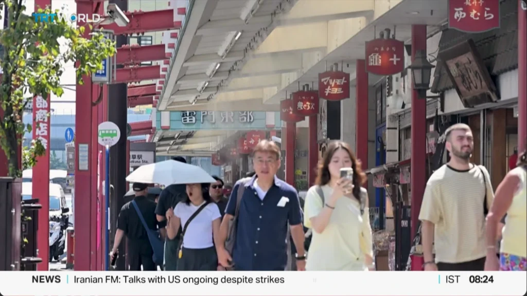 Pedestrians in Japan use umbrellas for shade during extreme summer heat