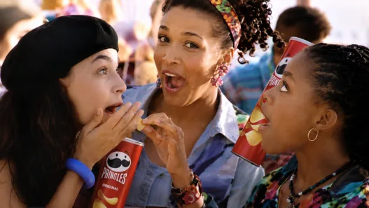Kym Whitley sharing Pringles with two women in a scene from her 1994 television commercial.