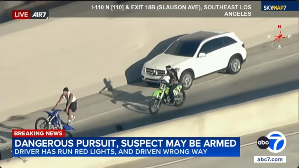 Motorcyclists approach a fleeing Mercedes-Benz during a police chase on the northbound 110 Freeway
