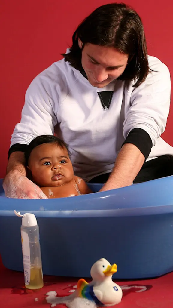 Lionel Messi helping bathe baby Lamine Yamal during a 2007 UNICEF calendar photo shoot