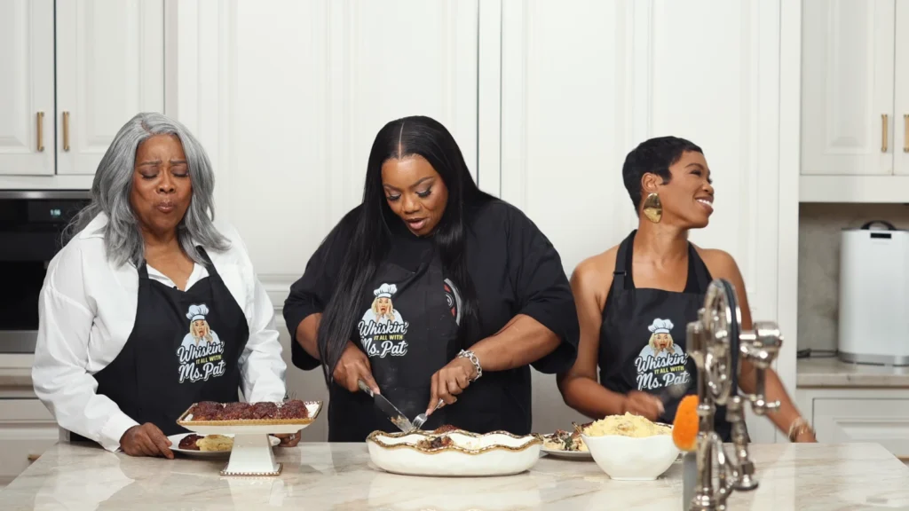 Miss Pat mixing meatloaf while Loretta Devine watches