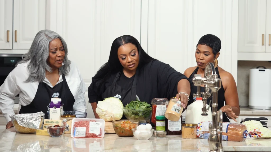 Loretta Devine tasting the finished food with Miss Pat