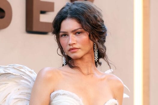 Zendaya wearing a white feathered wing gown and diamond earrings at The Odyssey New York premiere