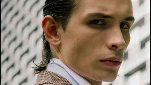 Close portrait of Anton Kügler in a checked Acne Studios coat and white shirt outdoors