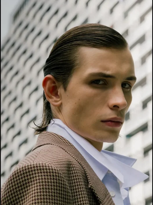 Close portrait of Anton Kügler in a checked Acne Studios coat and white shirt outdoors