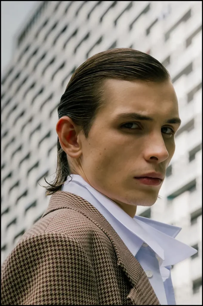 Close portrait of Anton Kügler in a checked coat and white shirt outdoors