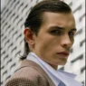 Close portrait of Anton Kügler in a checked Acne Studios coat and white shirt outdoors