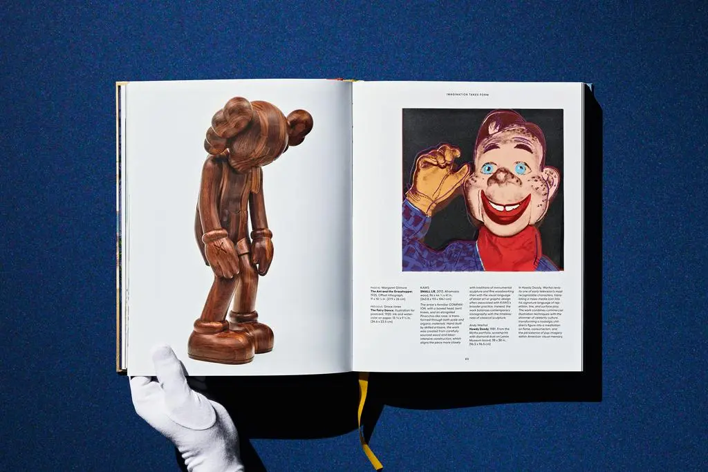 Gloved hands hold open a Lucas Museum of Narrative Art spread with a sculptural figure and colorful portrait illustration.