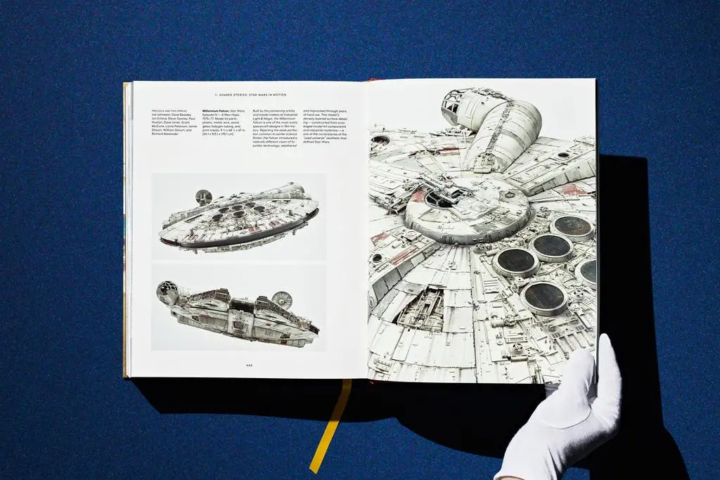 Gloved hands hold open a Lucas Museum of Narrative Art spread filled with black-and-white concept drawings.
