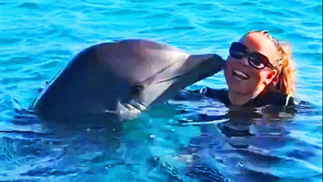 Mariah Carey beside a dolphin during their viral whistle-note exchange
