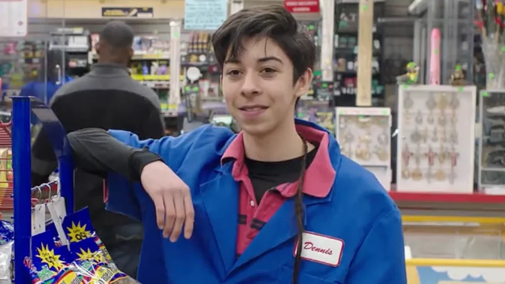 Fabrizio Zacharee Guido as Dennis aka Baby Joker in a blue store uniform in Family