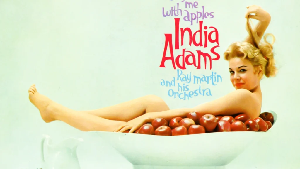 India Adams reclining in a bathtub filled with red apples on the Comfort Me with Apples album cover