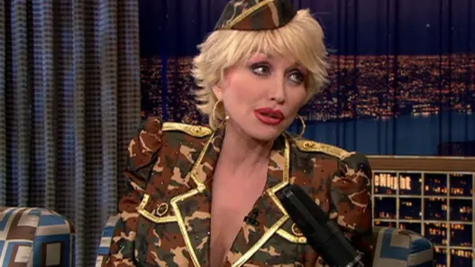 Dolly Parton with short blonde hair and a military-inspired camouflage outfit on Conan in 2003