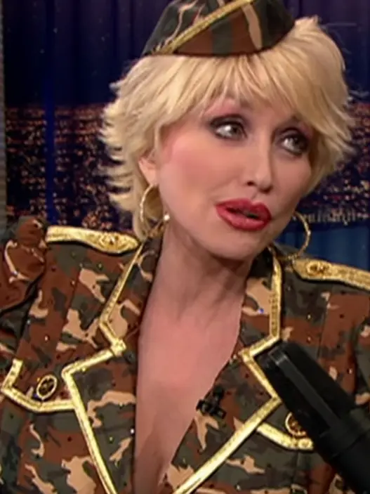 Dolly Parton with short blonde hair and a military-inspired camouflage outfit on Conan in 2003