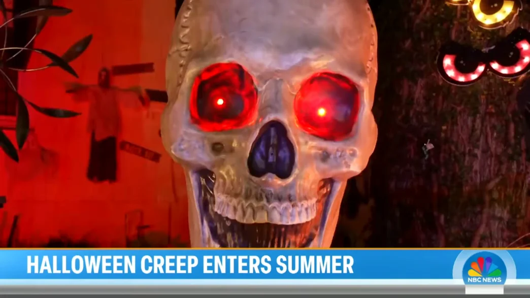 Large Halloween skull decoration with glowing red eyes beside a light-up spider