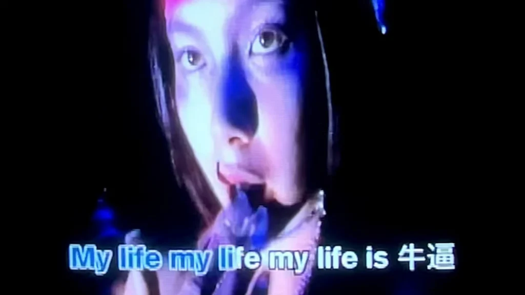Blue-lit close-up with the lyric My life is niu bi displayed in English and Chinese