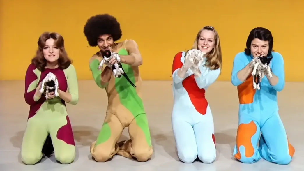 Four Ballet Zoom dancers kneel in colorful 1970s costumes during a psychedelic cat-themed television performance